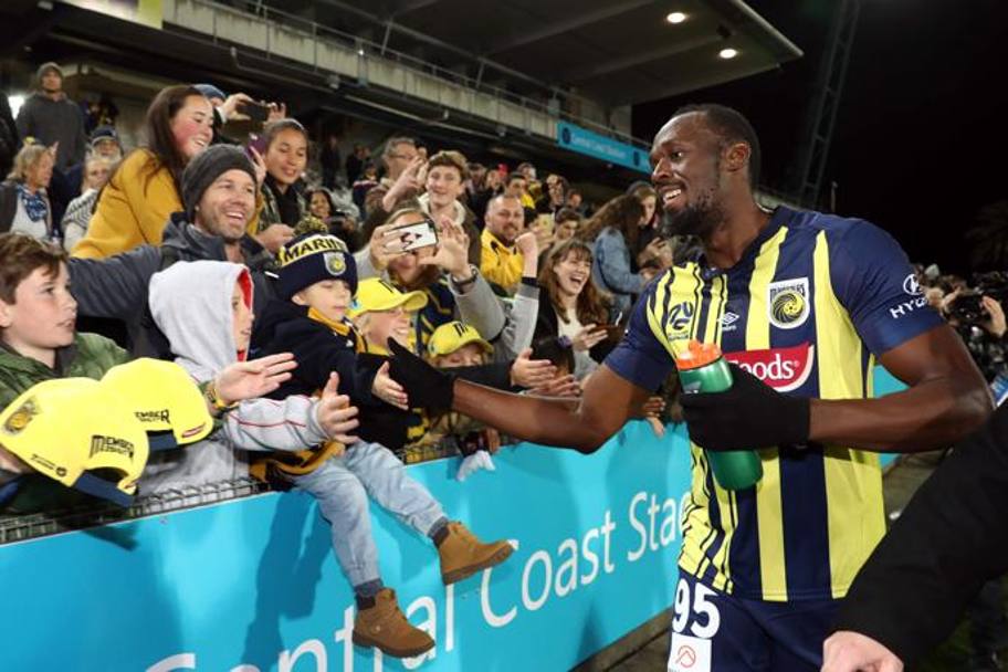 Usain Bolt saluta i fan a fine partita. Afp